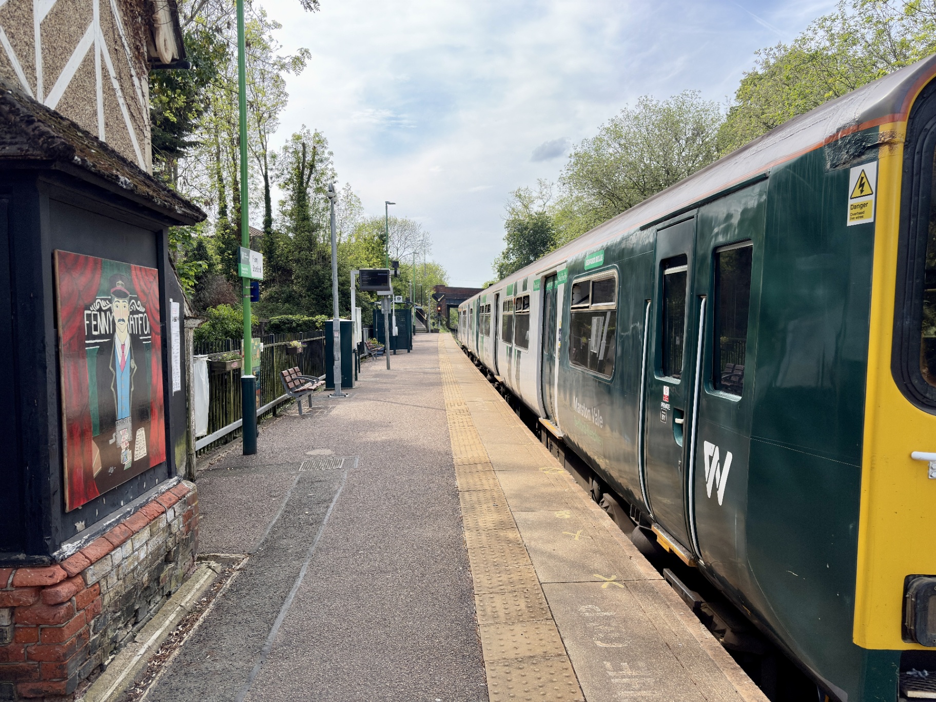 Heritage railway station at golden hour with signal box and tracks curving away